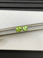 Two light green peridot cushion cut gemstones