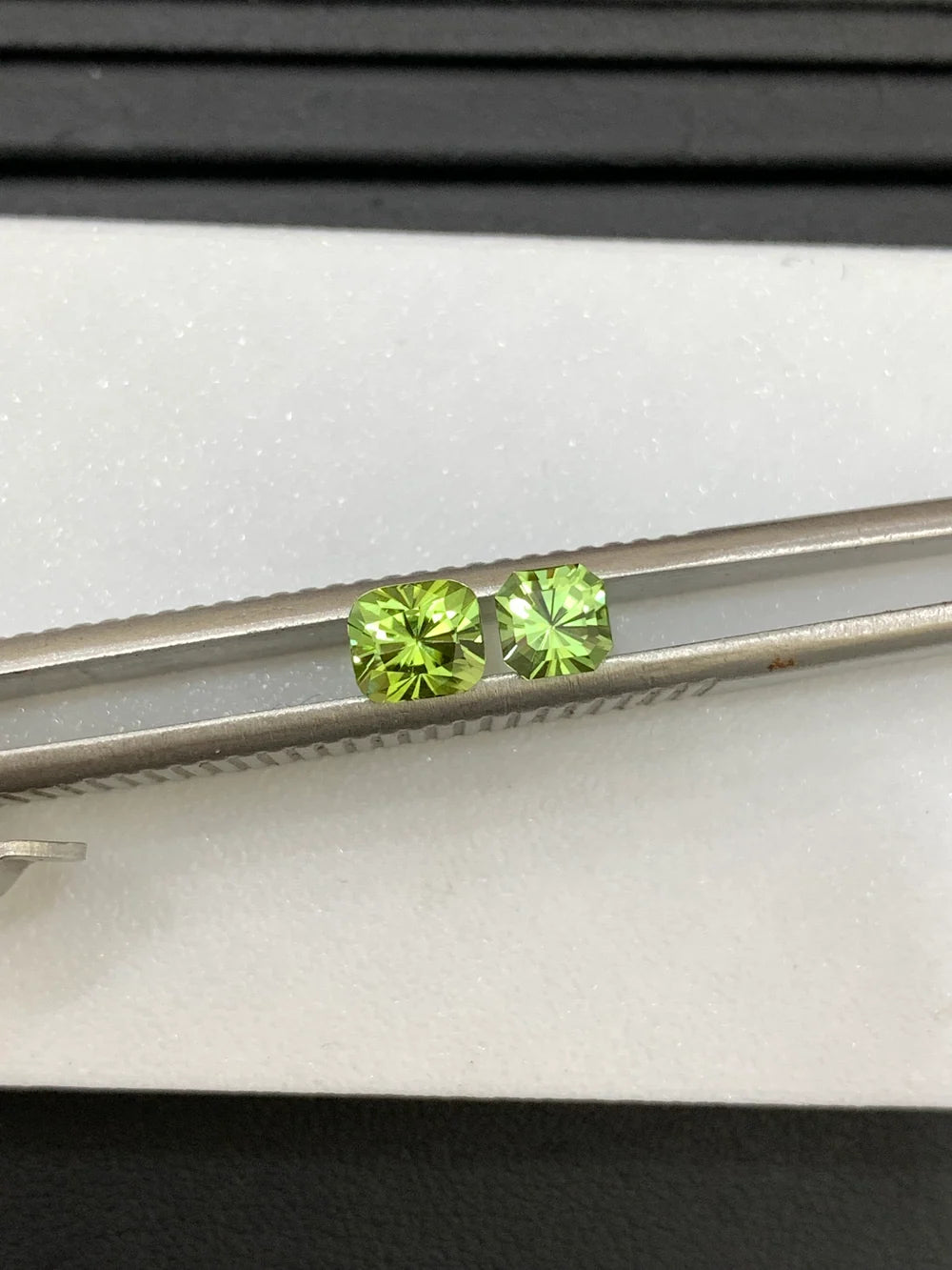 Two light green peridot cushion cut gemstones