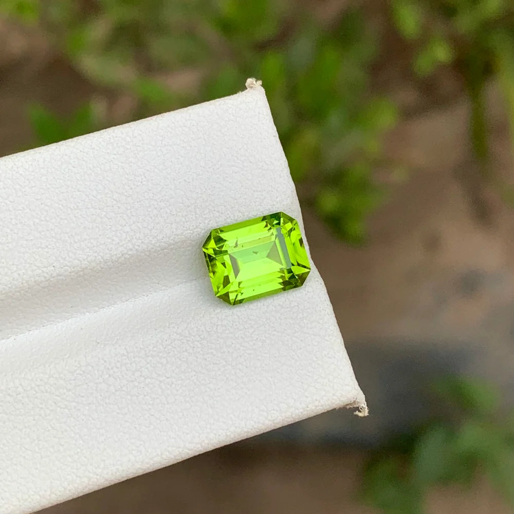 Shop a 3.75 Ct apple green peridot from Pakistan with an elegant emerald cut. Natural untreated loose August birthstone for custom jewelry.