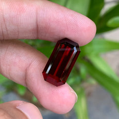 Discover the rich beauty of this 14.20-carat deep red rhodolite garnet from Africa, expertly cut in an elegant emerald cut.