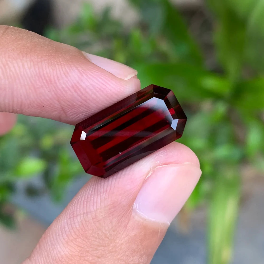 Shop a 14.20 Ct deep red rhodolite garnet from Africa with an elegant emerald cut. Untreated January birthstone for custom jewelry and collections.
